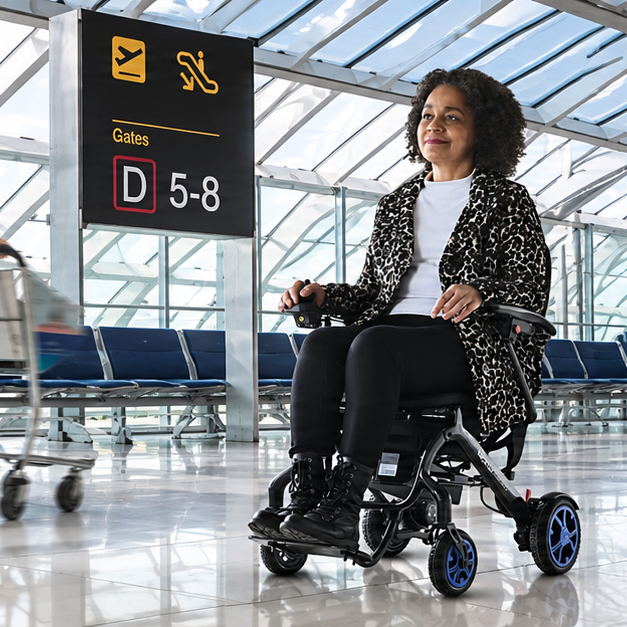 Frau im faltbaren Elektrorollstuhl am Flughafen auf dem Weg zum Gate